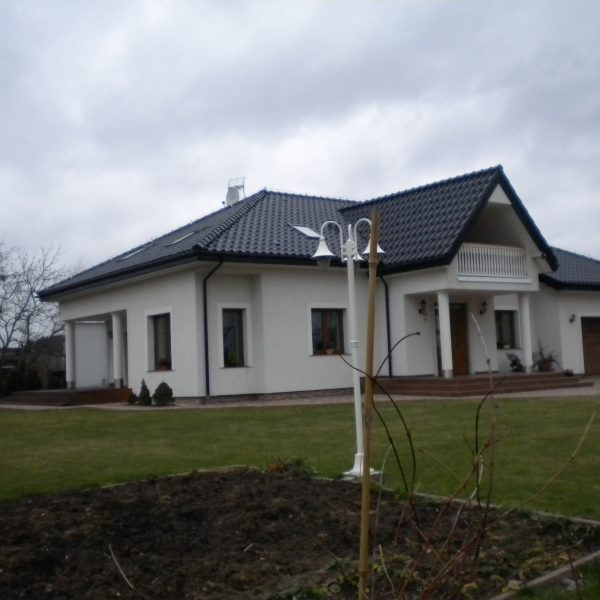 Połyskująca dachówka Röben Monza Plus Tobago na eleganckim dachu dwuspadowym.